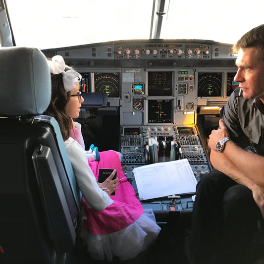 Founder daughter sitting with a pilot in the cock pit