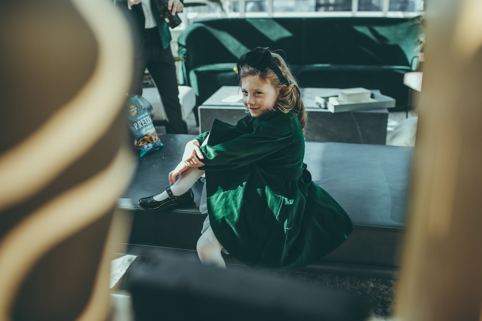 Little girl sitting in a green velvet dress.